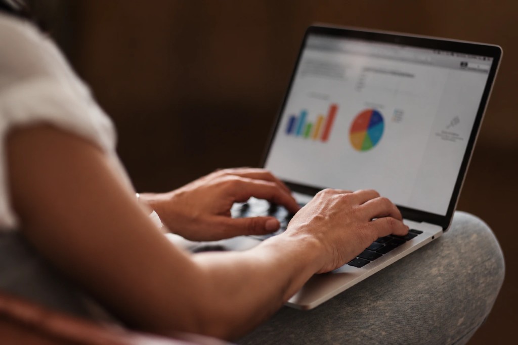 A person reviews campaign charts on a laptop